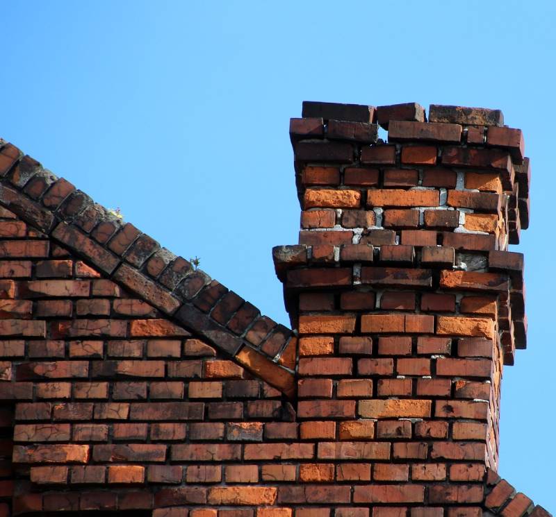 Signs Your Warrenville Home Needs a Chimney Inspection Damaged chimney on an Warrenville home showing cracks and missing mortar